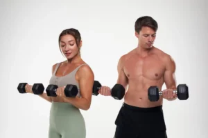 Man and woman exercising with dumbbells on a white background.